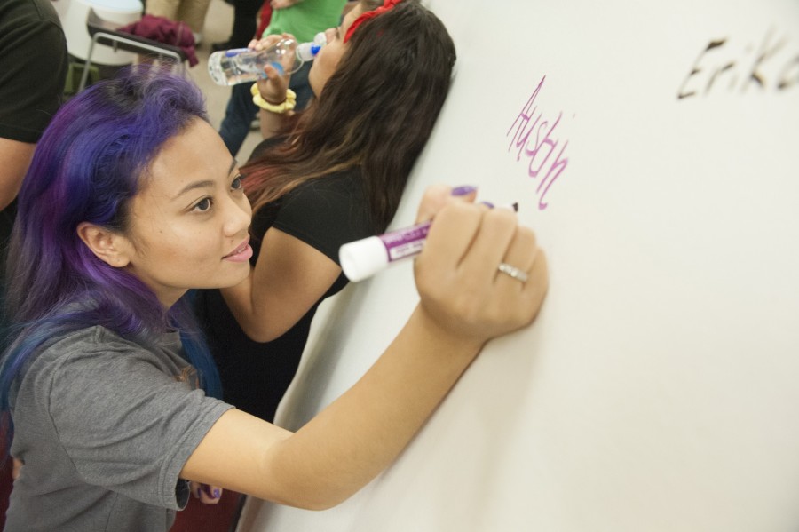Austin Bui joins a startup team by writing down her name on the wall.jpg